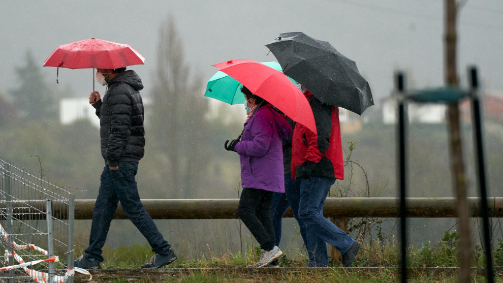 Varias personas se refugian con un paraguas de la lluvia