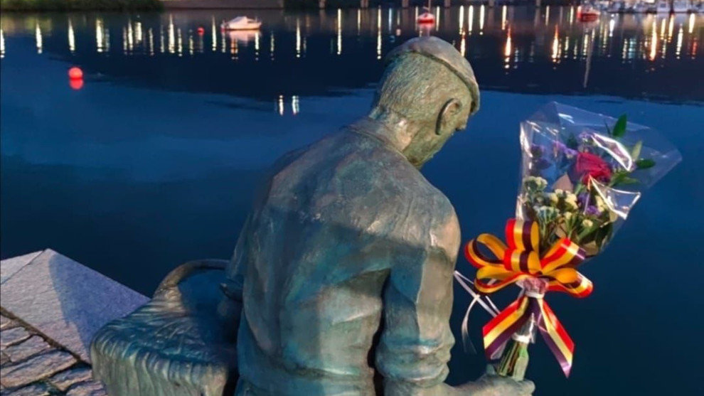 Estatua del pescador en el muelle e Astillero con flores por las víctimas en accidentes laborales