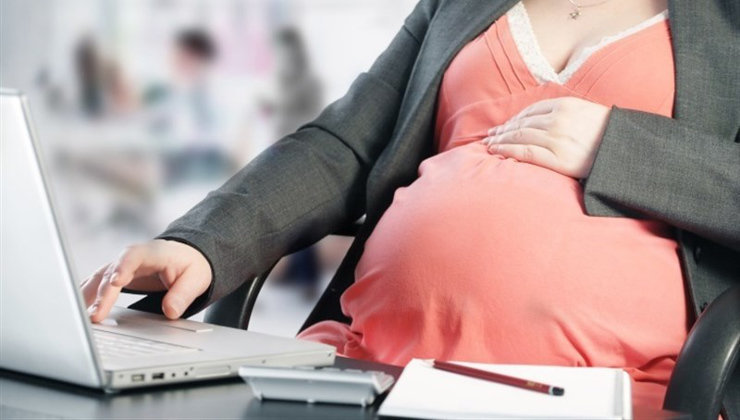 Una mujer embarazada con el ordenador