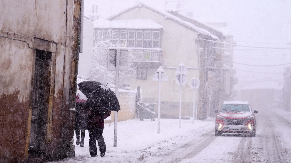 Una persona camina por una calle cubierta de nieve