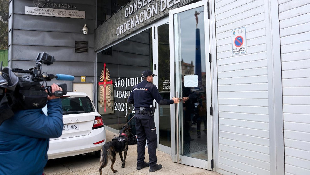 Un agente de la Policía Nacional entra con un perro a las dependencias de la Consejería de Obras Públicas