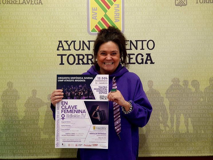 La concejala de Cultura de Torrelavega, Esther Vélez, con el cartel del concierto 'Enclave Femenina IV' que correrá a cargo de la Orquesta Sinfónica Juvenil UIMP-Ataúlfo Argenta