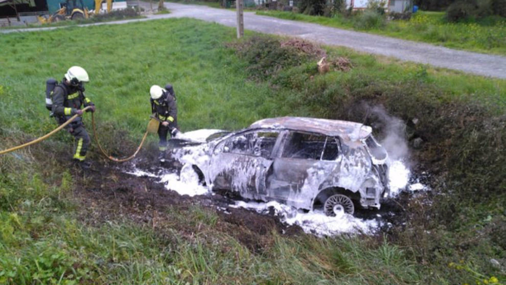 Bomberos del 112 del Parque de Emergencias de Laredo apagan el incendio en el vehículo accidentado