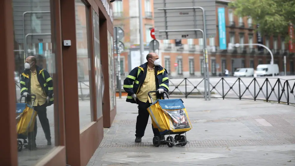 Un trabajador de Correos durante su jornada laboral tras la presentaci&oacute;n de la empresa de un plan de desescalada