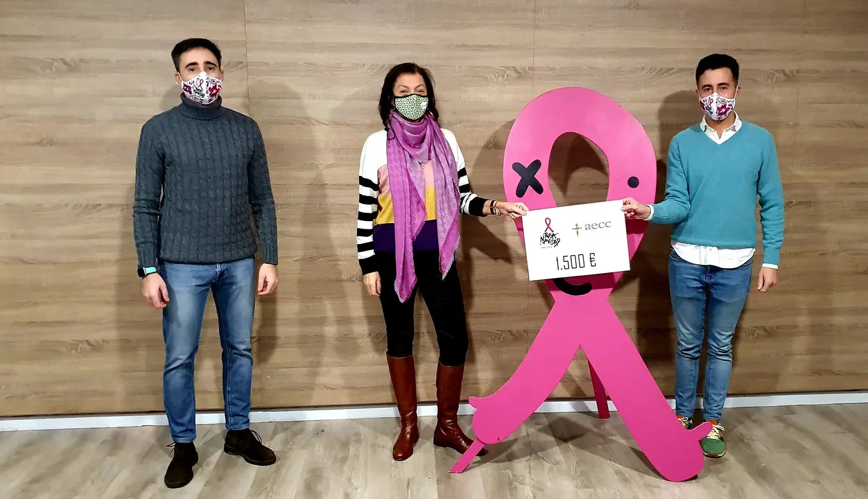 Representantes de la Asociaci&oacute;n Rosa Navidad de Torrelavega entregan a la AECC la recaudaci&oacute;n obtenida de la venta de papeletas de la Loter&iacute;a de Navidad