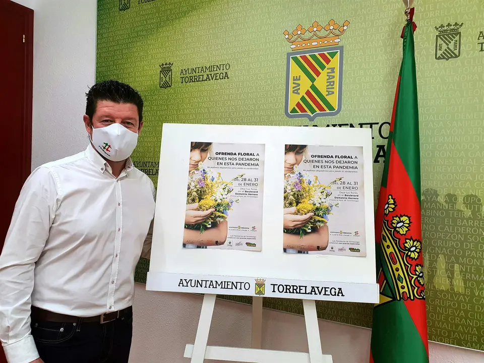 El concejal de Dinamizaci&oacute;n Social de Torrelavega, Jes&uacute;s S&aacute;nchez, junto al carte de la ofrenda floral a los fallecidos del Covid