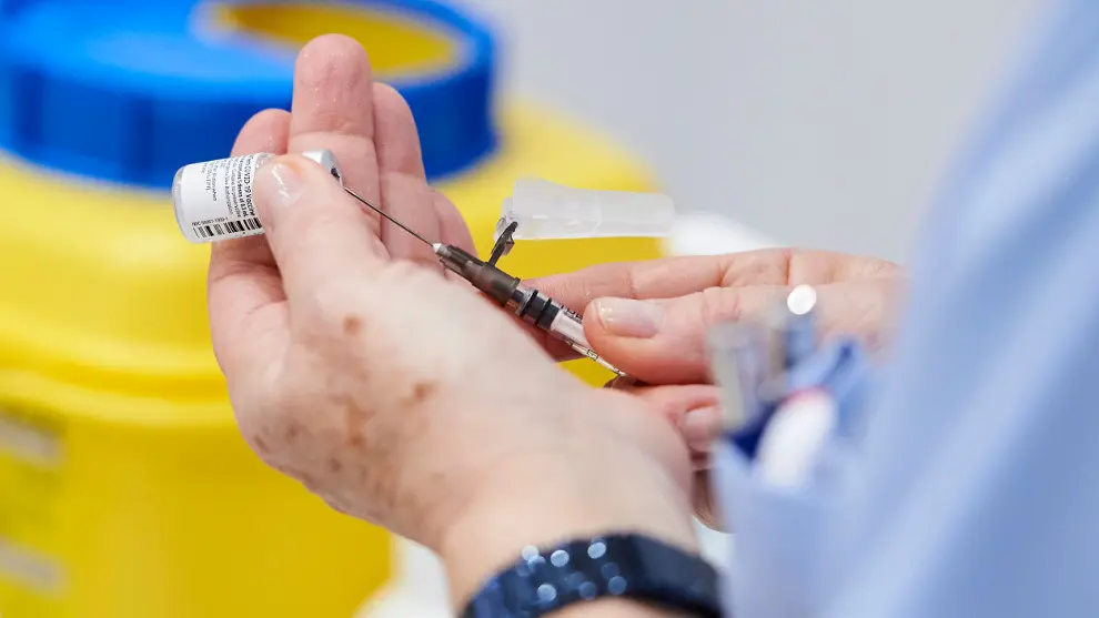 Una trabajadora sanitaria sostiene una jeringuilla