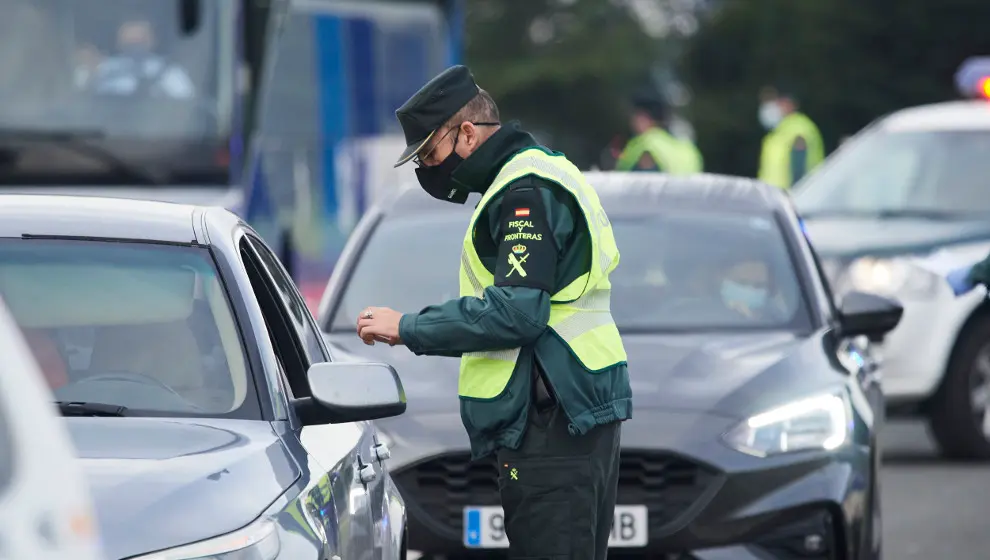 Un agente de la Guardia Civil pide la documentación a un vehículo durante un control efectuado en Laredo, Cantabria