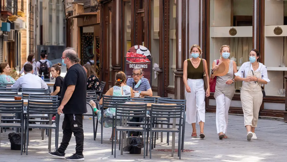 Tres jóvenes pasean con mascarillas