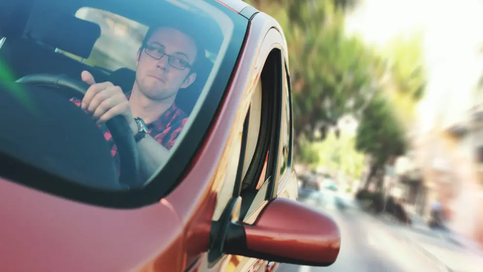 Un chico conduciendo su coche