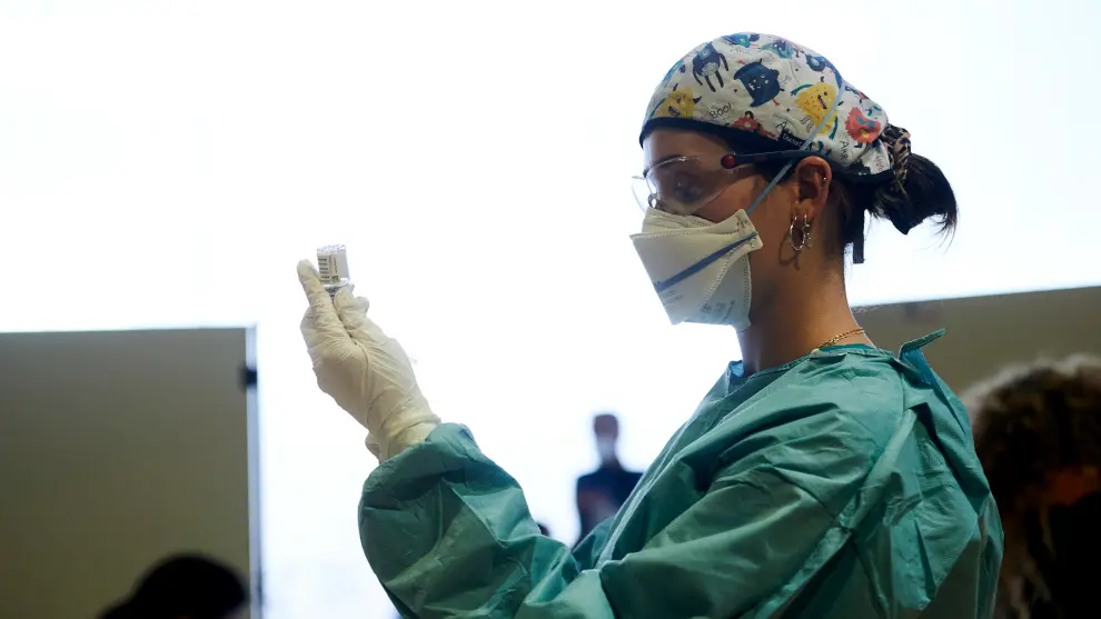 Una profesional sanitaria sostiene un vial con la vacuna de AstraZeneca