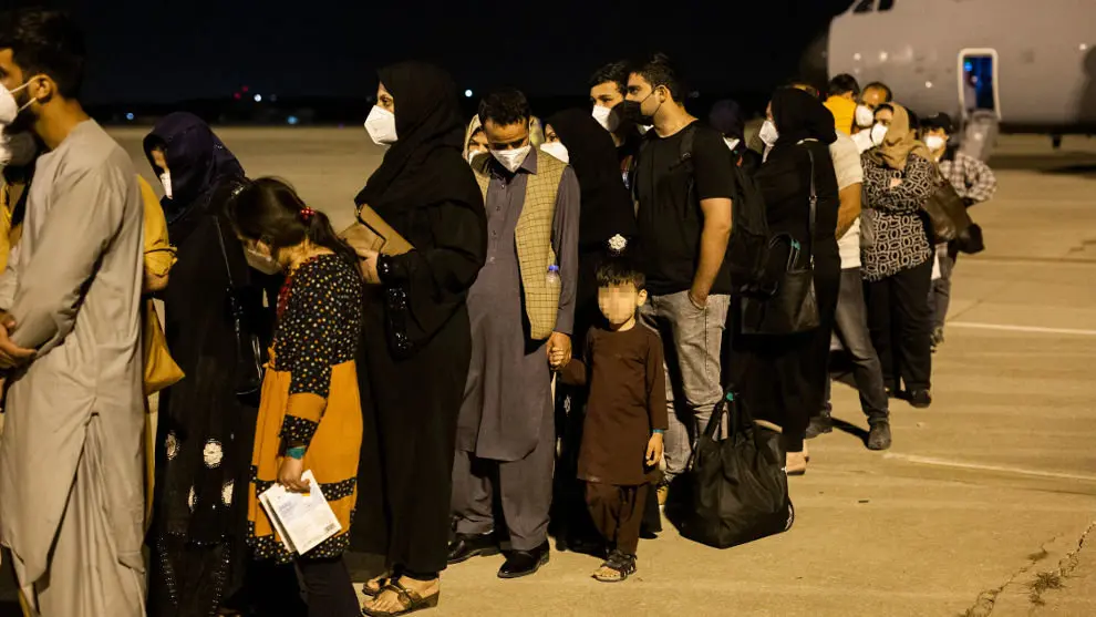 Varias personas repatriadas llegan a la pista tras bajarse del avión A400M en el que han sido evacuados de Kabul