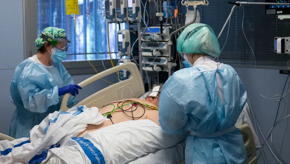 Personal sanitario atendiendo a un paciente ingresado en la Unidad de Cuidados Intensivos (UCI) para enfermos de coronavirus