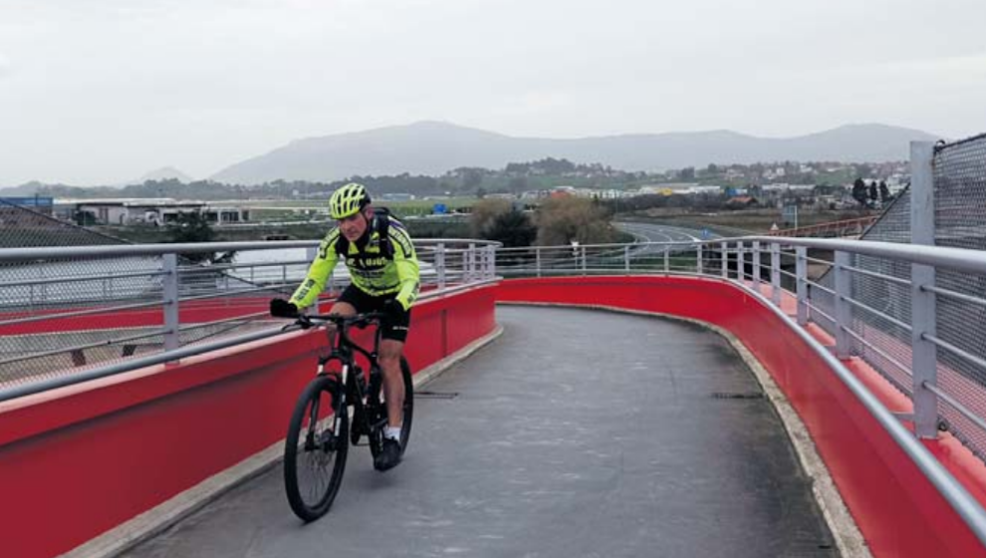 Hombre atraviesa un puente montado en bicicleta