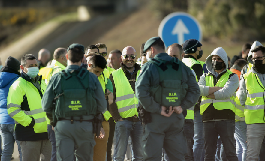 Dos agentes de la Guardia Civil hablan con los miembros de un piquete que han cortado la A-6 en ambos sentidos a la altura de Guitiriz, a 18 de marzo de 2022, en Guitiriz, Lugo, Galicia