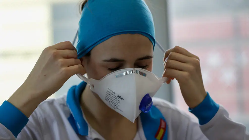 Una enfermera se coloca una mascarilla
