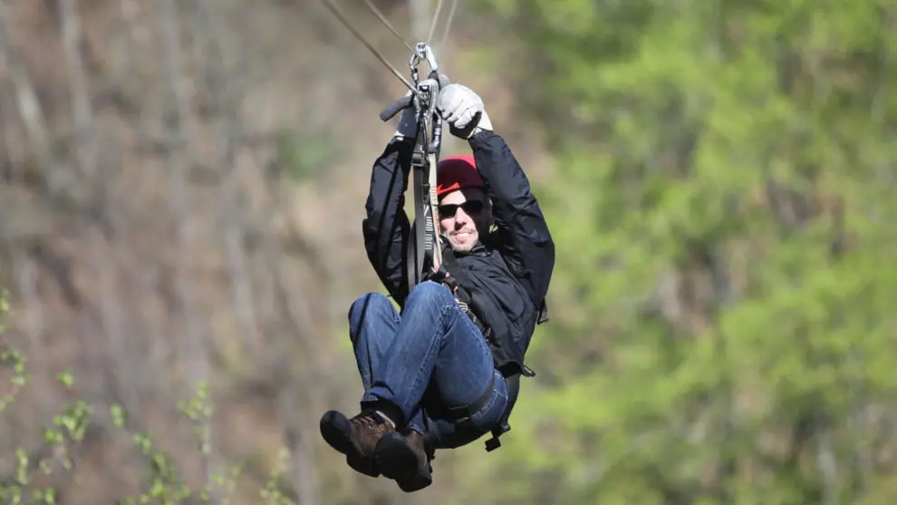 Un hombre tirándose por una tirolina
