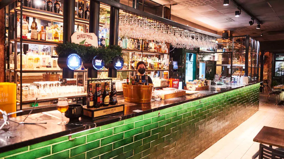 Una trabajadora en la barra de un bar vacía