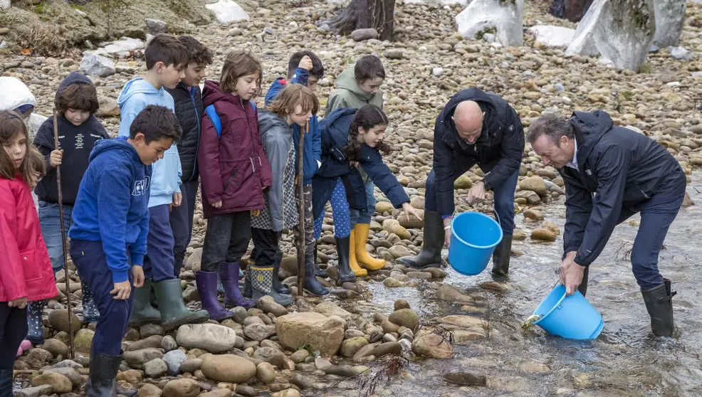 El consejero de Pesca, Guillermo Blanco, participa junto a un grupo de alumnos en la suelta de alevines de salmón en el Pas