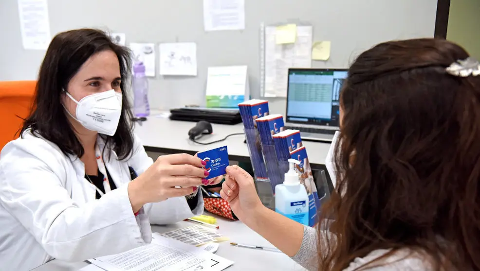 Una sanitaria entrega a una voluntaria lal tarjeta del proyecto Cohorte Cantabria