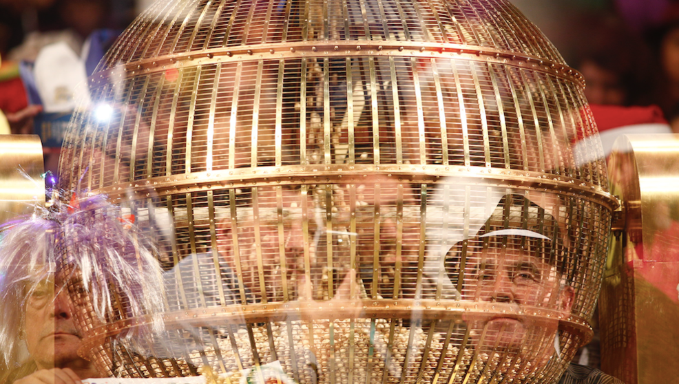 Personas disfrazadas detr&aacute;s de un bombo esperan en el Teatro Real de Madrid para disfrutar del Sorteo Extraordinario de la Loter&iacute;a de Navidad