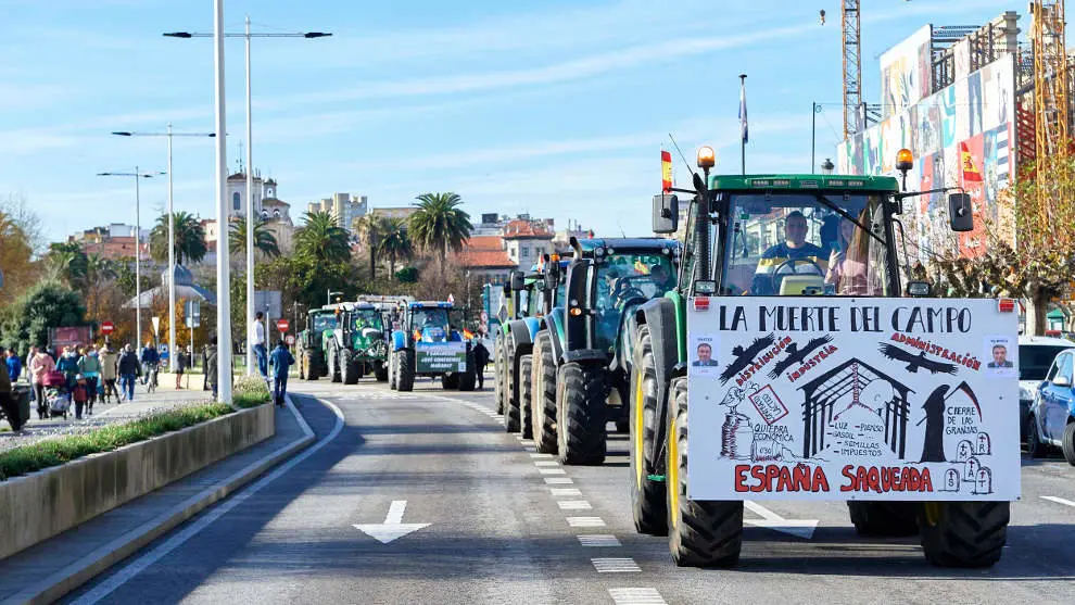 Varios tractores circulan por una carretera en una manifestaci&oacute;n de profesionales de la ganader&iacute;a