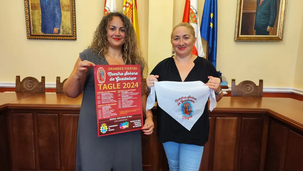 La concejala Raquel Fern&aacute;ndez y la presidenta de la Junta Vecinal, Rebeca Pern&iacute;a, con el cartel y el pa&ntilde;uelo de las fiestas de Guadalupe