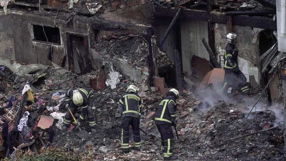 Agentes del equipo de bomberos trabaja en el edificio derrumbado,