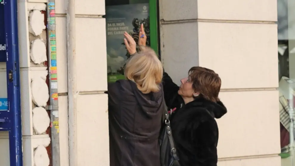 Dos mujeres cierran la persiana de su negocio