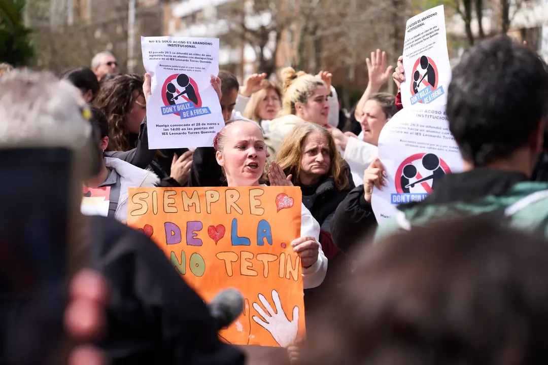 Varias personas con carteles durante una concentración de apoyo al joven agredido en el IES Torres Quevedo