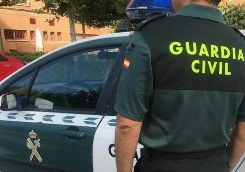 Imagen de archivo de un agente de la Guardia Civil ante un coche patrulla
