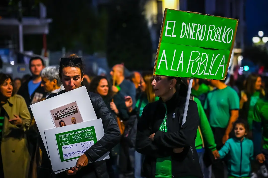 Varias personas con pancartas, durante una manifestación del profesorado cántabro por la adecuación salarial