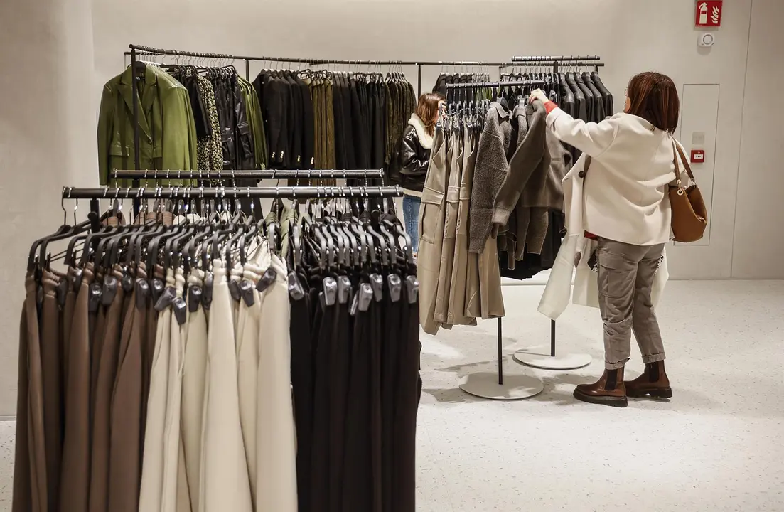 Archivo - Una mujer ve la ropa en una macrotienda de Zara.