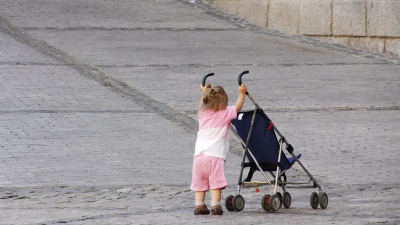 Una ni&ntilde;a empuja una silla de beb&eacute;
