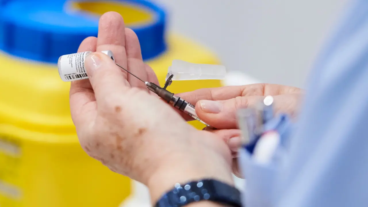 Una trabajadora sanitaria sostiene una jeringuilla