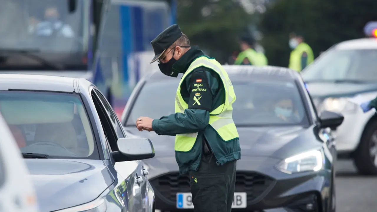Un agente de la Guardia Civil pide la documentación a un vehículo durante un control efectuado en Laredo, Cantabria