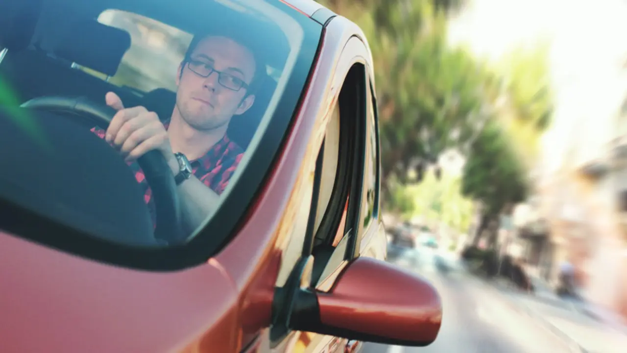 Un chico conduciendo su coche
