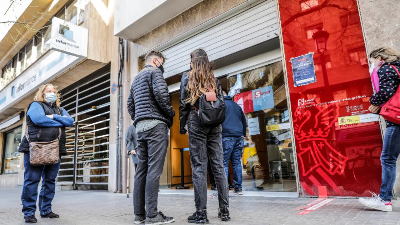 Personas esprean en una oficina con cita previa