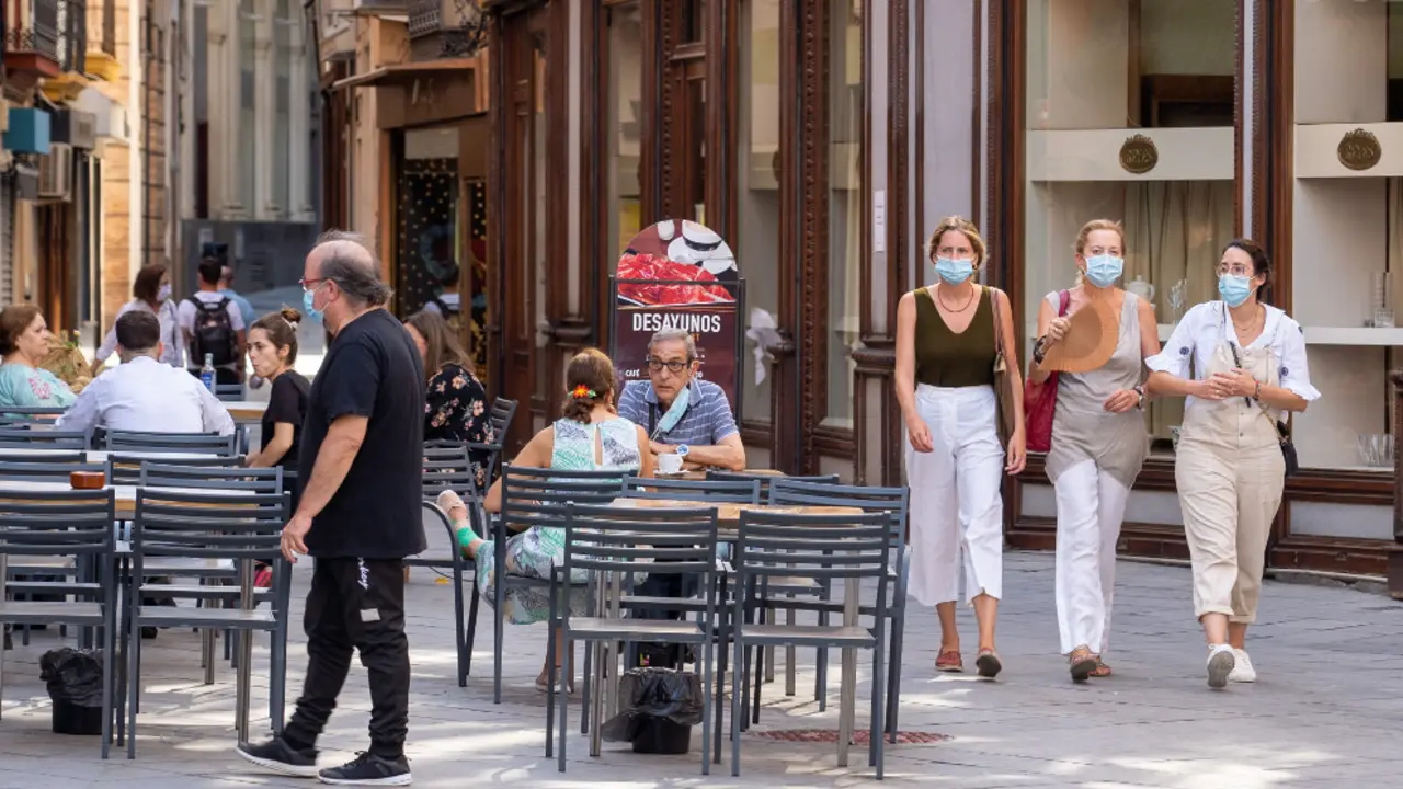 Tres jóvenes pasean con mascarillas