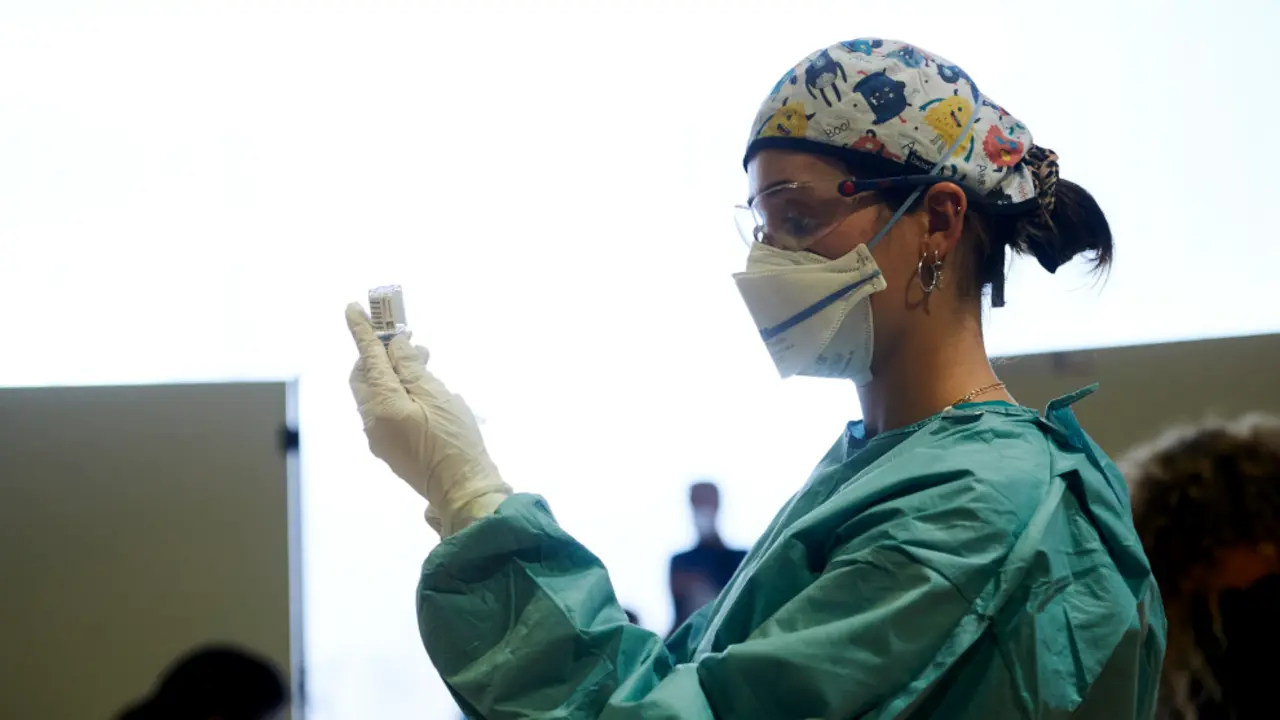 Una profesional sanitaria sostiene un vial con la vacuna de AstraZeneca