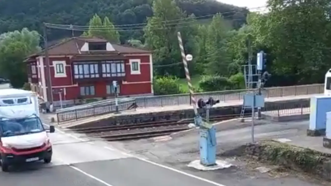 Instante en el que la furgoneta atraviesa las vías con el tren en marcha