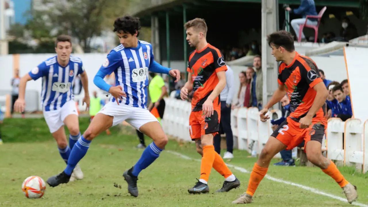 Un jugador de la UD Sámano disputa el balón a un futbolista de la Gimnástica