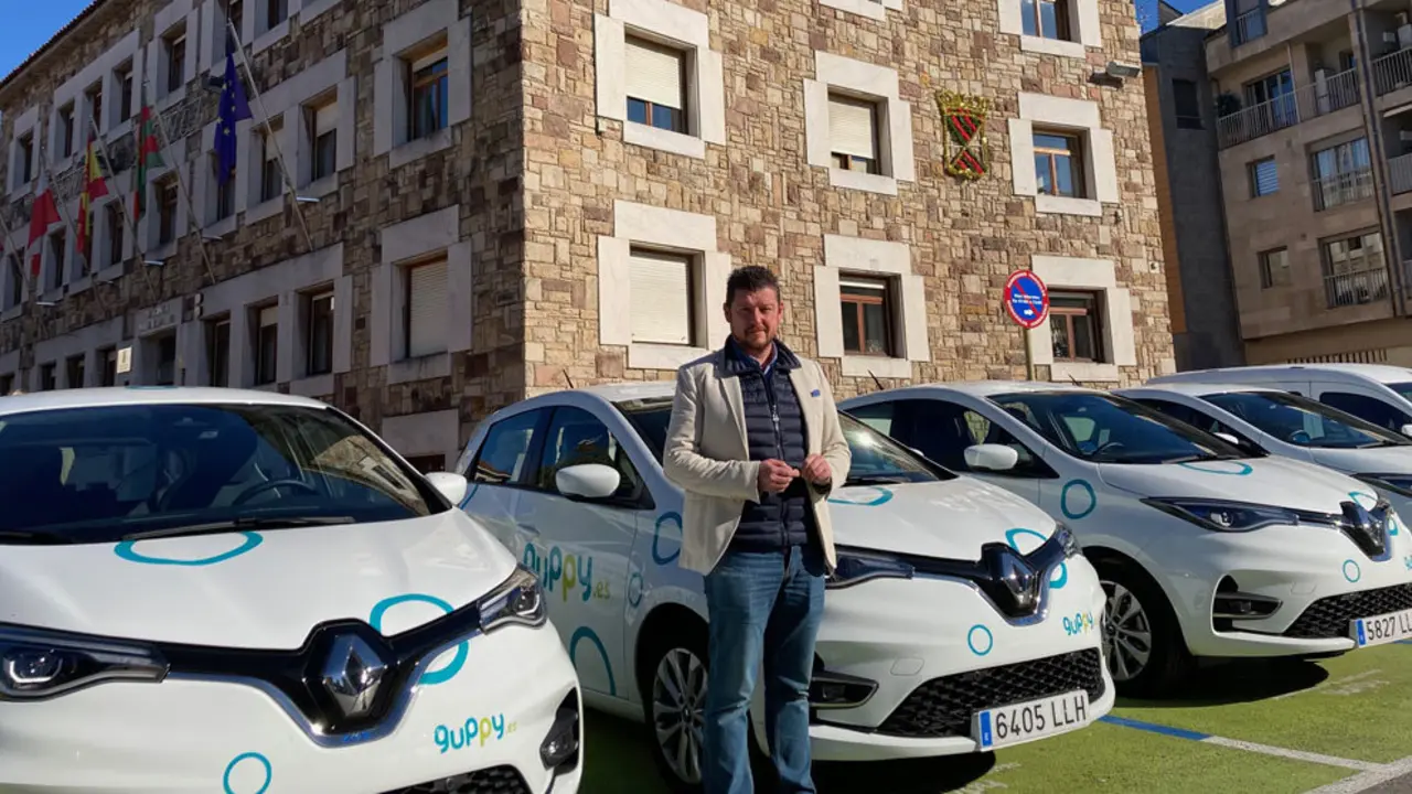 El concejal Jesús Sánchez junto a los vehículos Guppy aparcados junto a la sede del Ayuntamiento de Torrelavega