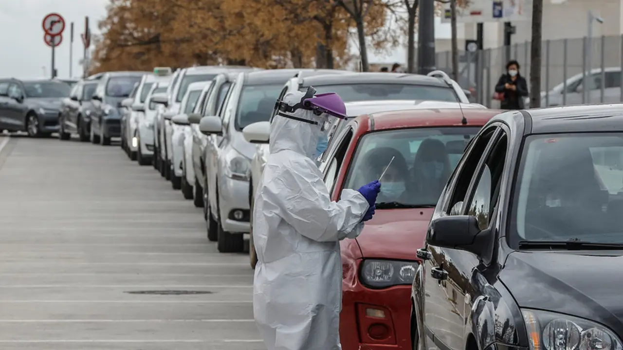 Un sanitario realiza una prueba PCR a una persona desde su vehículo para la detección del coronavirus