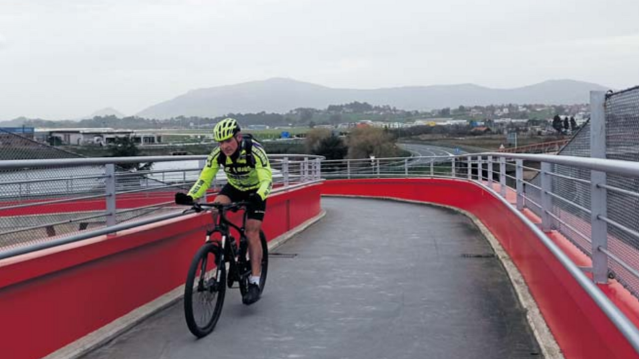 Hombre atraviesa un puente montado en bicicleta