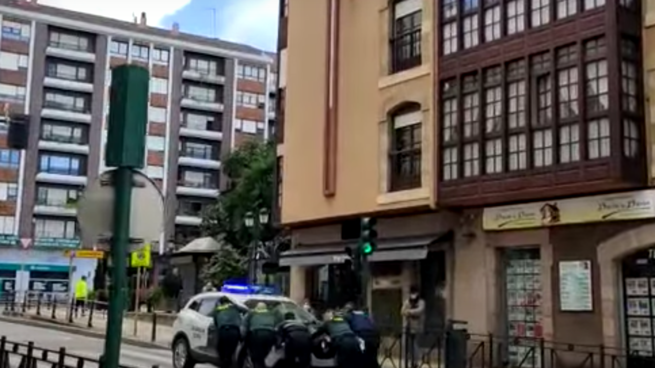 Efectivos de la Guardia Civil empujan un todoterreno en el cruce de Cuatro Caminos en Torrelavega