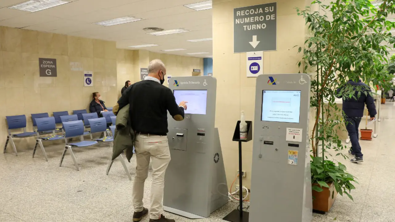 Un hombre recoge su turno en una oficina de la Agencia Tributaria