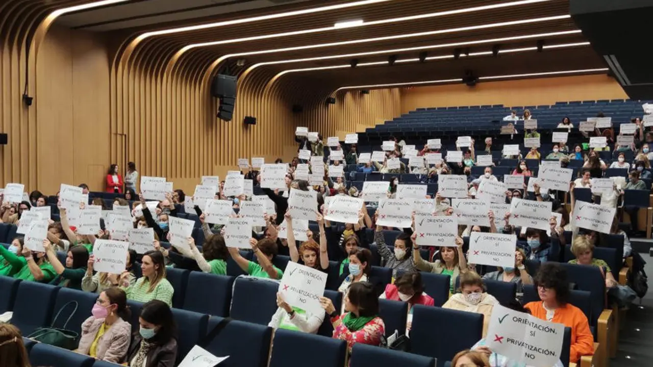 Orientadores educativos levantan pancartas a favor de este servicio público en un acto con cargos de la Consejería