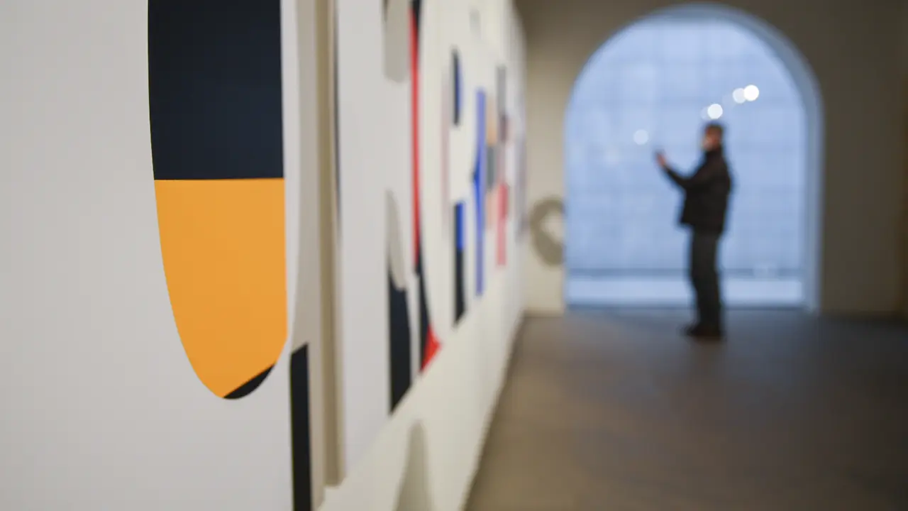 Una persona contempla varias obras de dise&ntilde;o gr&aacute;fico y tipogr&aacute;fico