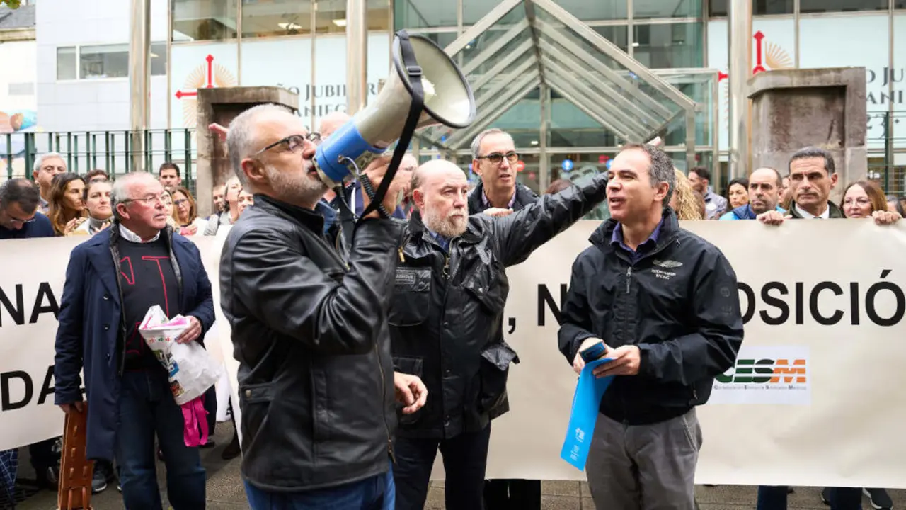 Un miembro del sindicato médico de Santander Óscar Ortiz (i) con un megáfono y otro miembro del sindicato médico Santiago Raba (d), durante la concentración de médicos de Atención Primaria